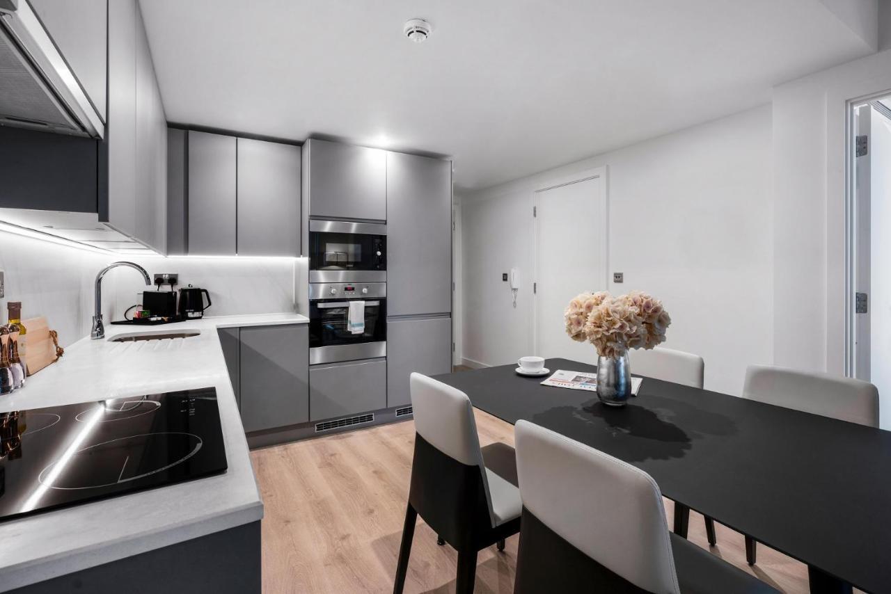 Citysuites 2 Aparthotel Manchester Esterno foto The photo shows a modern kitchen and dining area. The kitchen features sleek gray cabinets, a countertop with an embedded cooktop, and built-in appliances, including an oven and microwave. There’s a small coffee maker on the counter. Adjacent to the 