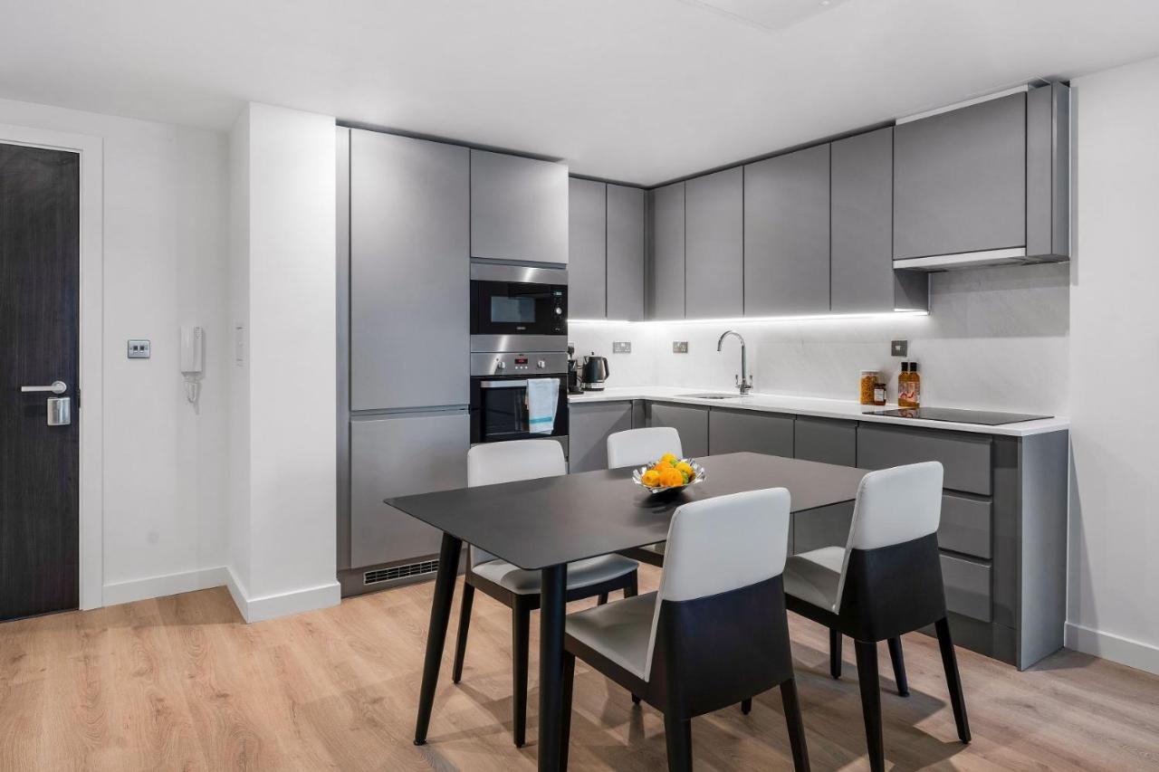 Citysuites 2 Aparthotel Manchester Esterno foto The photo shows a modern kitchen with a sleek and minimalist design. The cabinetry features a gray finish, and there are built-in appliances, including an oven and possibly a microwave. The countertop is light-colored, providing contrast to the darke