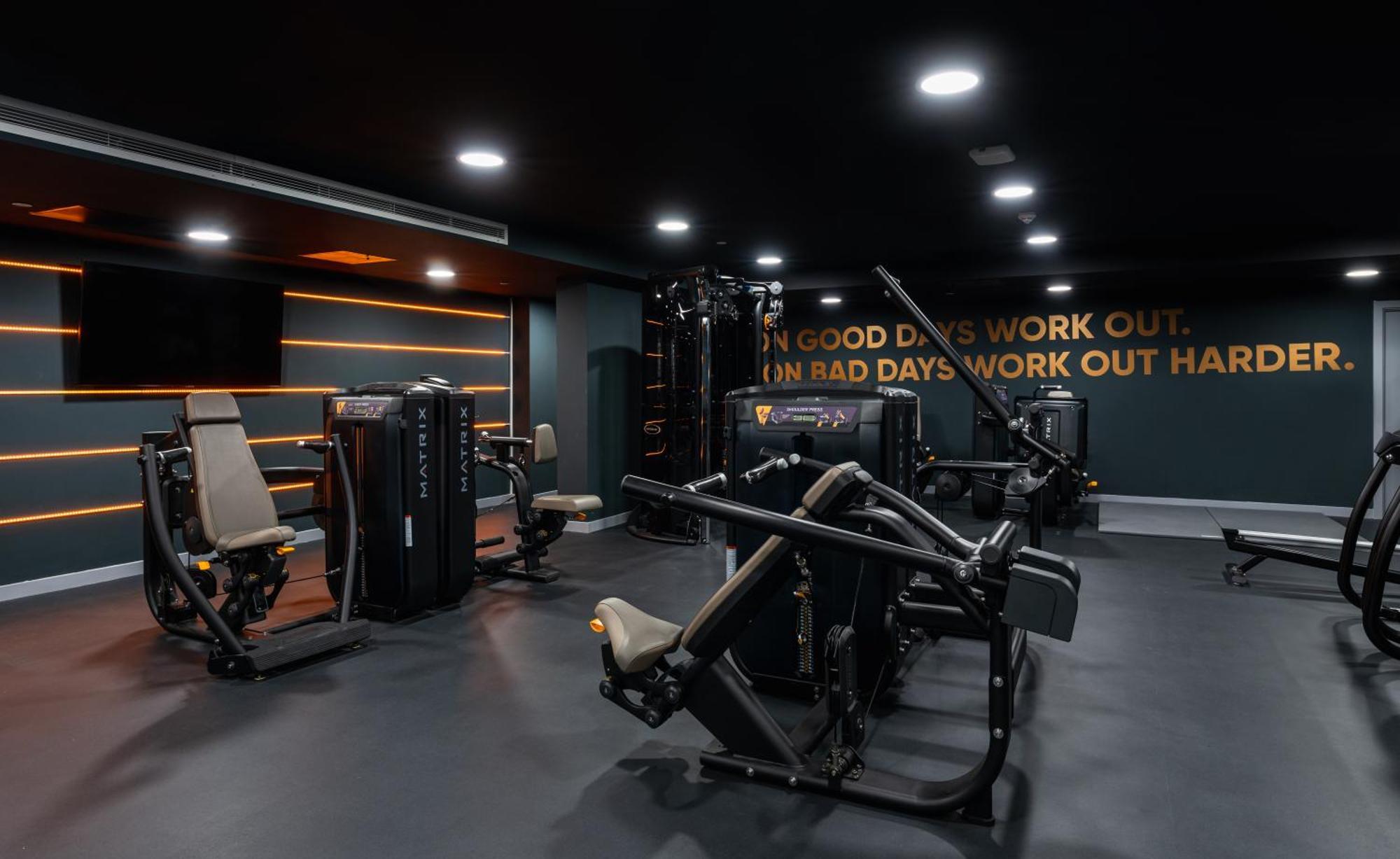 Citysuites 2 Aparthotel Salford  Esterno foto The photo shows a modern gym interior. The gym features various exercise machines, including weight training equipment. The flooring is dark, and the walls are adorned with motivational text that reads, "ON GOOD DAYS WORK OUT. ON BAD DAYS WORK OUT HA