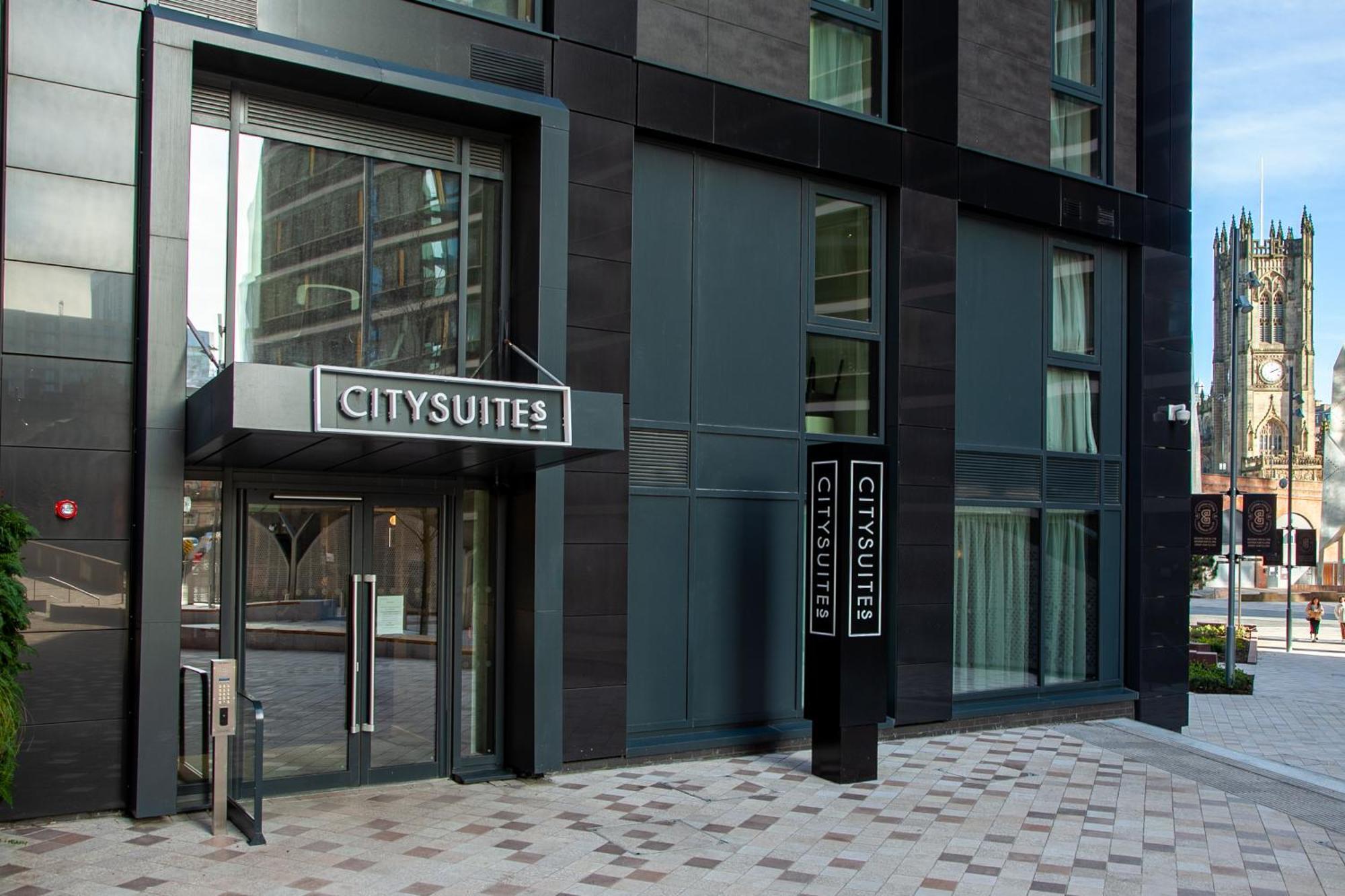 Citysuites 2 Aparthotel Salford  Esterno foto The photo shows the entrance to a modern building labeled "CITYSUITES." The entrance features large glass doors and a sleek, contemporary design. The building has dark exterior panels and large windows, suggesting a stylish and urban environment. The